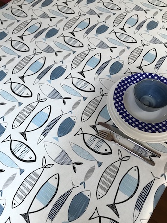 blue and white wipe over outdoor tablecloth with fish designs